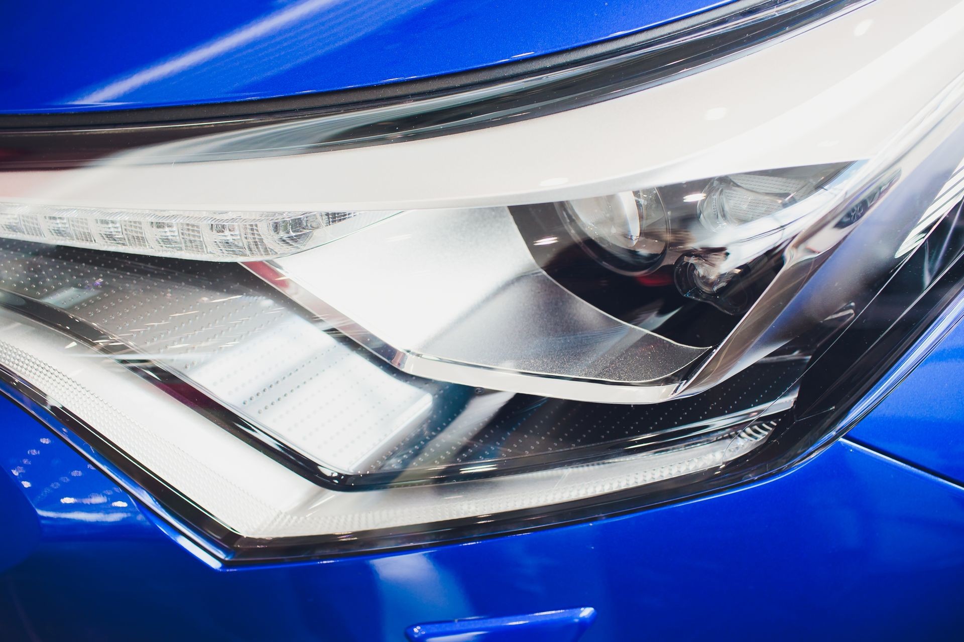 Close up shot headlight in luxury blue car background. Modern and expensive sport car concept